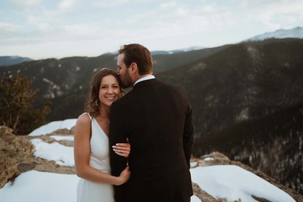 Mountain top vows and ceremony at a Evergreen elopement. Golden hour portraits, snowy viewpoint.