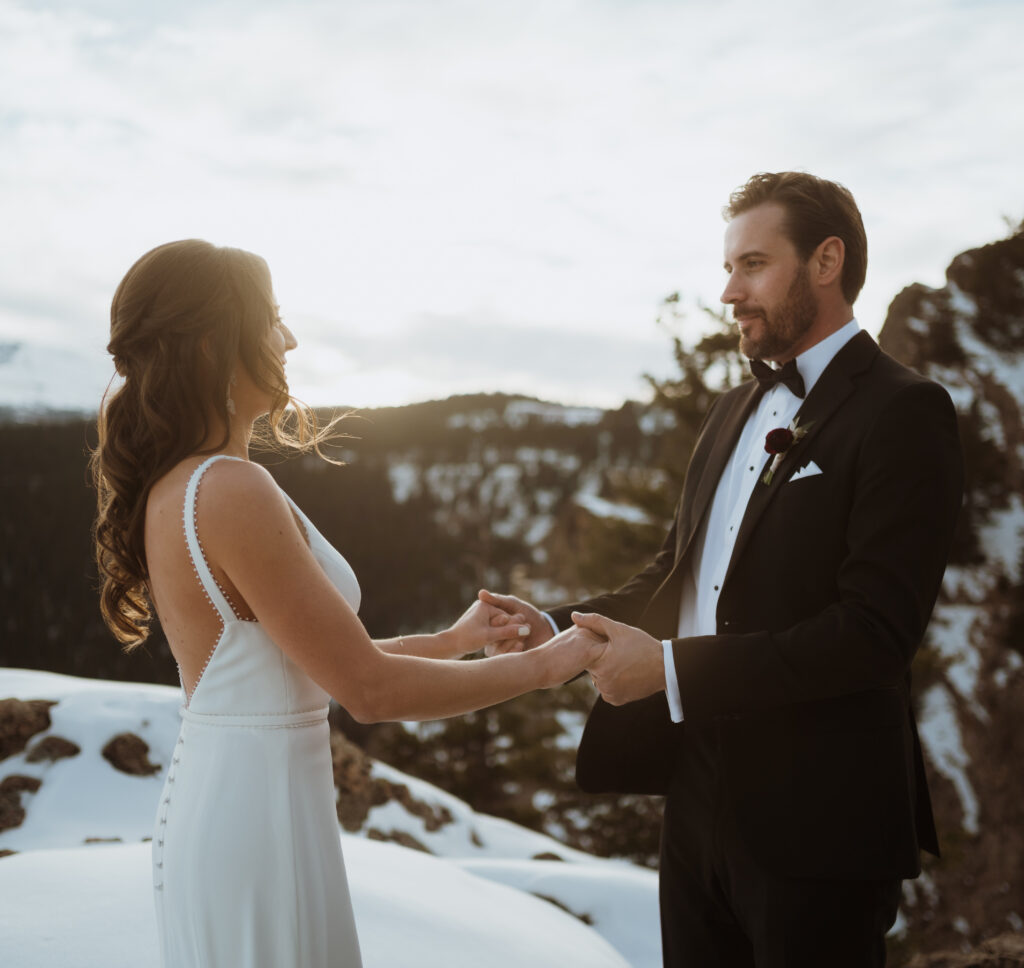 Mountain top vows and ceremony at a Evergreen elopement. Golden hour portraits, snowy viewpoint.